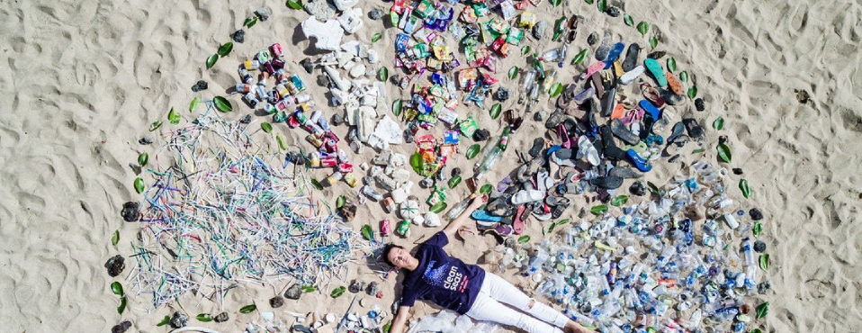girl surrounded by plastic on the beach